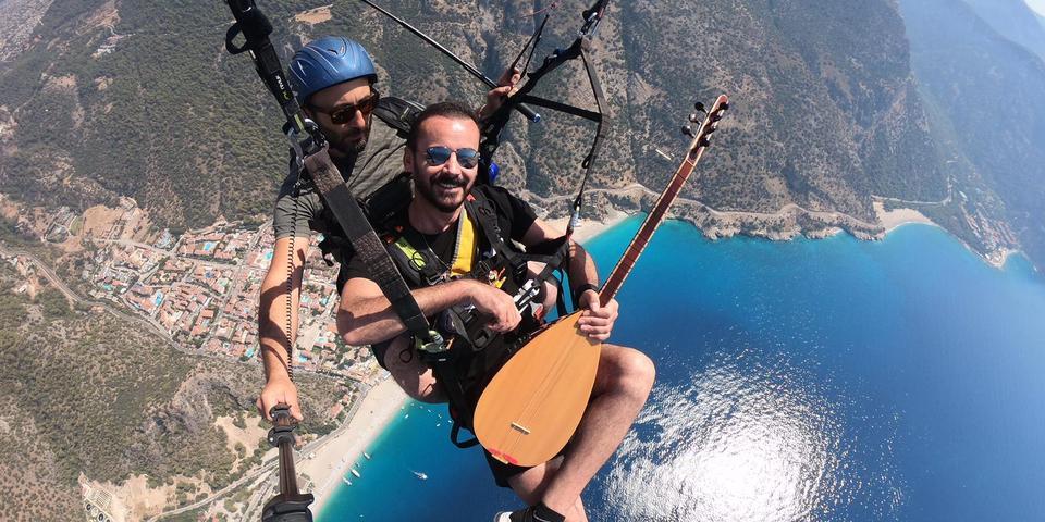 Muğla'nın Fethiye ilçesinde yamaç paraşütü pilotuyla atlayış yapan ses sanatçısı Seyfi Yerlikaya, yüzlerce metre yüksekte Ölüdeniz manzarasında saz çalıp türkü söyledi.