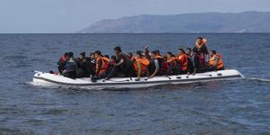 An inflatable boat filled with refugees and other migrants approaches the north coast of the Greek island of Lesbos. Turkey is visible in the background. More than 500,000 migrants have crossed from Turkey to the Greek islands so far in 2015. (An infl