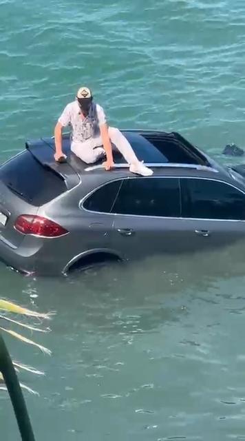 AYVALIK'TA OTOMOBİL DENİZE UÇTU ARAÇ SÜRÜCÜSÜ BATAN ARACIN ÜZERİNDE DAKİKALARCA KURTARILMAYI BEKLEDİ