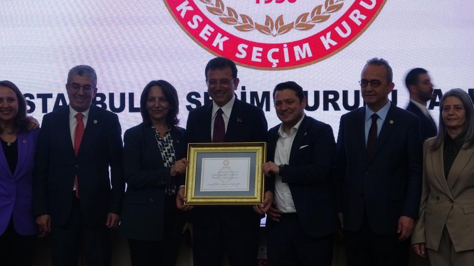 31 Mart Mahalli İdareler Seçimleri'nde yeniden İstanbul Büyükşehir Belediye Başkanlığına seçilen Ekrem İmamoğlu, mazbatasını teslim aldı.
31 Mart Mahalli İdareler Seçimleri'nde İstanbul Büyükşehir Belediye Başkanı seçilen Ekrem İmamoğlu mazbatasını teslim aldı. Çağlayan’da bulunan İstanbul Adalet Sarayı’nın konferans salonunda düzenlenen teslim törenine İmamoğlu’nun yanı sıra eşi Dilek İmamoğlu, İstanbul İl Seçim Kurulu Başkanı Ramazan Seçkin ile üyeler, protokol de katıldı. İl Seçim Kurulu Başkanı Seçkin’in açılış konuşmasıyla başlayan törende hatıra fotoğrafları da çekildi.