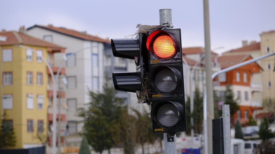 KARAMAN'IN EN İŞLEK KAVŞAĞINDAKİ TRAFİK LAMBASINA YUVA YAPAN KUMRU GÖRENLERİ ŞAŞIRTIYOR