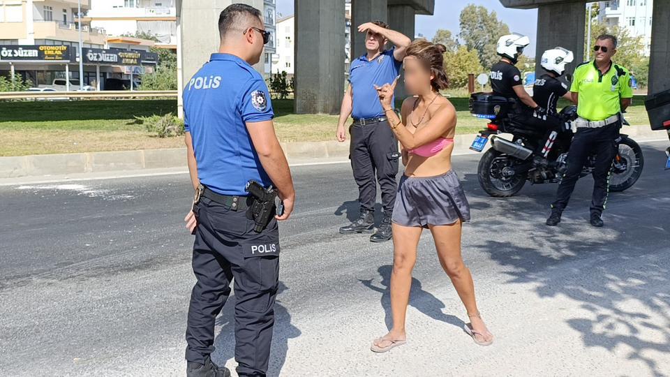 POLİS EKİPLERİNİN TRAFİKTEKİ BİKİNİLİ GENÇ KADINLA İMTİHANI ÜZERİNE TİŞÖRT GİYMESİ SÖYLENİNCE ÇILGINA DÖNDÜ, 'NİYE GİYECEKMİŞİM, TURİSTİM BEN' DİYE TEPKİ GÖSTERDİ MERSİN'DEKİ OĞLUNUN YANINA GİTMEK İSTEDİĞİNİ ANCAK UÇAK, OTOBÜS VE TAKSİLERİN KENDİSİNİ ALMADIĞINI İLERİ SÜREN GENÇ KADIN, POLİS EKİPLERİNE ZOR ANLAR YAŞATTI GENÇ KADIN, POLİS OTOSUYLA OTOGARA GÖTÜRÜLEREK OTOBÜSE BİNDİRİLDİ