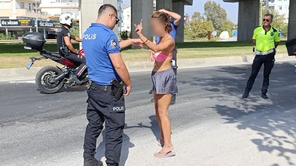 POLİS EKİPLERİNİN TRAFİKTEKİ BİKİNİLİ GENÇ KADINLA İMTİHANI ÜZERİNE TİŞÖRT GİYMESİ SÖYLENİNCE ÇILGINA DÖNDÜ, 'NİYE GİYECEKMİŞİM, TURİSTİM BEN' DİYE TEPKİ GÖSTERDİ MERSİN'DEKİ OĞLUNUN YANINA GİTMEK İSTEDİĞİNİ ANCAK UÇAK, OTOBÜS VE TAKSİLERİN KENDİSİNİ ALMADIĞINI İLERİ SÜREN GENÇ KADIN, POLİS EKİPLERİNE ZOR ANLAR YAŞATTI GENÇ KADIN, POLİS OTOSUYLA OTOGARA GÖTÜRÜLEREK OTOBÜSE BİNDİRİLDİ