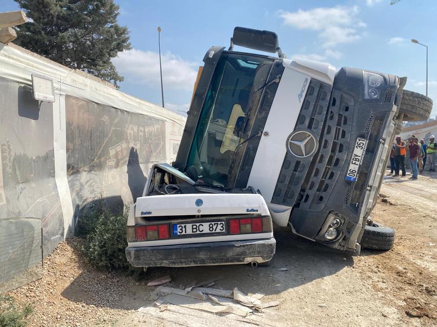 Kamyon otomobilin üzerine devrildi