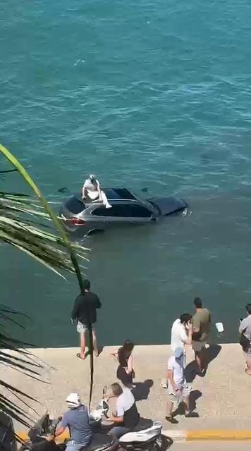 AYVALIK'TA OTOMOBİL DENİZE UÇTU ARAÇ SÜRÜCÜSÜ BATAN ARACIN ÜZERİNDE DAKİKALARCA KURTARILMAYI BEKLEDİ