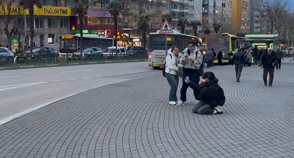 FIRTINADA UÇMAMAK İÇİN YERLERE BÖYLE YATTILAR LODOSUN HIZI SAATTE 75 KİLOMETREYE ULAŞTI, VATANDAŞLAR UÇMAMAK İÇİN YERLERE YATTI BURSA'DA LODOS VATANDAŞA ZOR ANLAR YAŞATTI