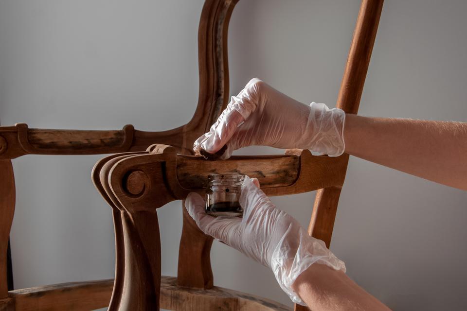 processing furniture stain with a swab made of lint-free cloth. all parts backrest, armrest, leg. Renovation of old furniture as an antique Victorian old wooden armchair