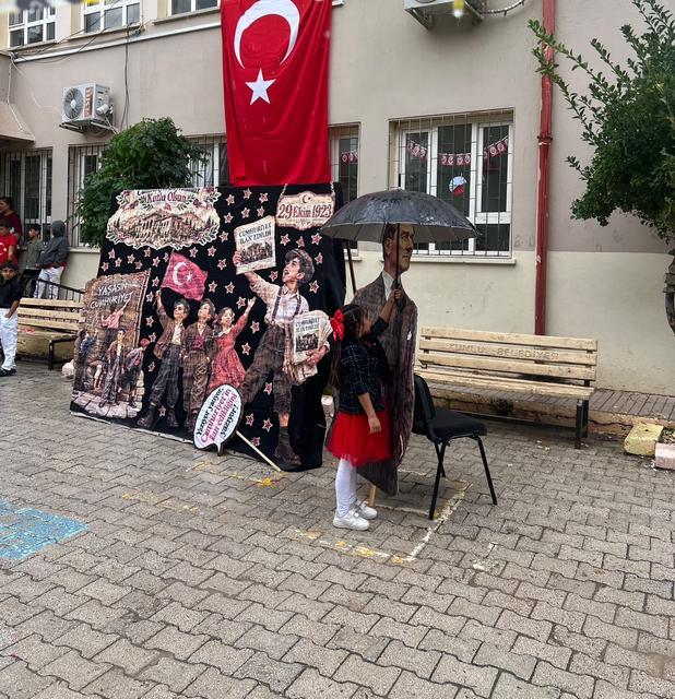 Yağmura aldırış etmeden Atasına şemsiye tutan Meryem, yürekleri ısıttı