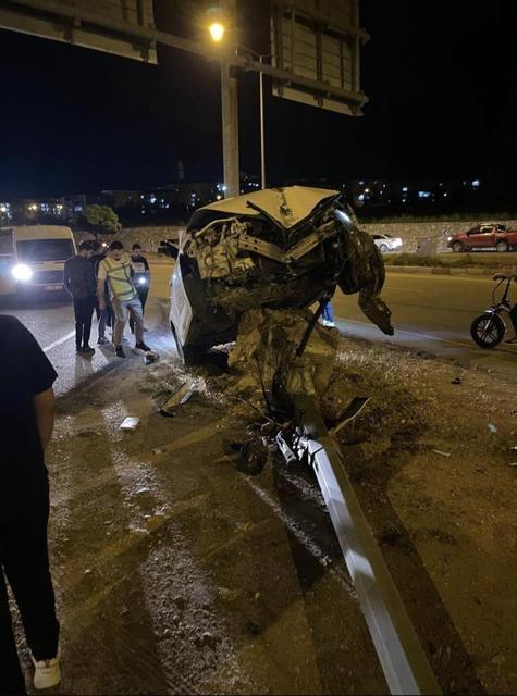 Aydınlatma direğine çarpan otomobil, beton kaidesi üzerinde asılı kaldı
