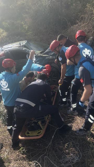 UÇURUMA DEVRİLEN OTOMOBİLİN KADIN SÜRÜCÜSÜ HALAT YARDIMIYLA KURTARILDI