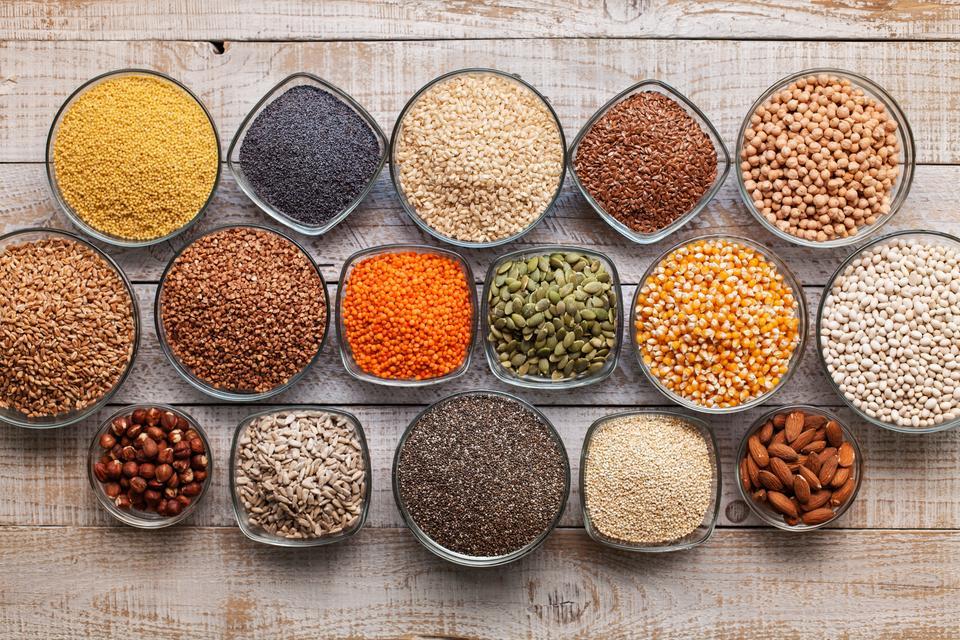 Various seeds, grains and nuts on old table, healthy diverse diet concept, top view